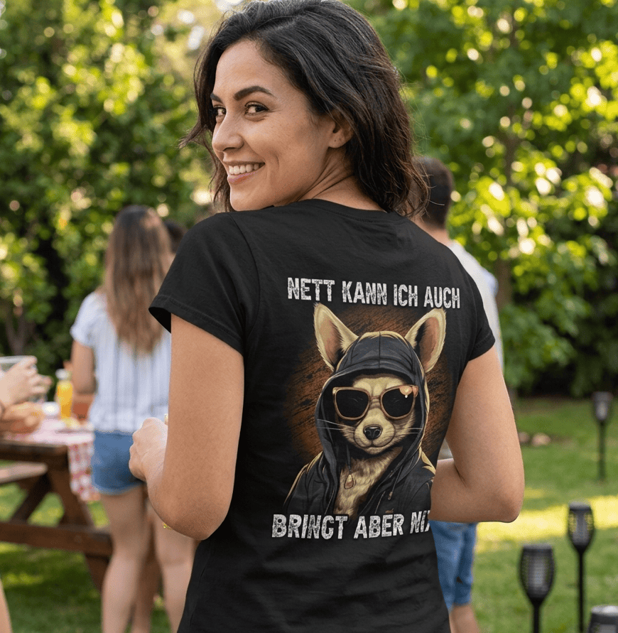 Eine fröhliche Frau trägt ein Shirt mit dem lustigen Spruch Nett kann ich auch bringt aber nix