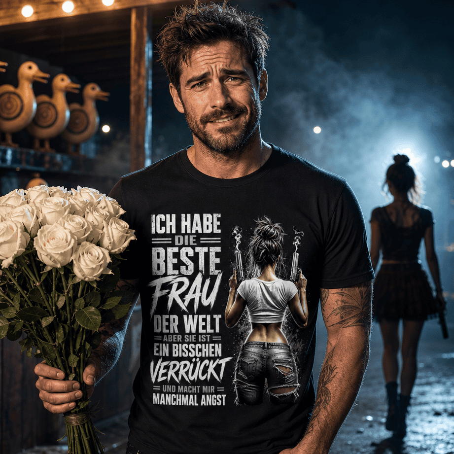 Mann trägt schwarzes T-Shirt mit humorvollem Ehe-Spruch in düsterer Jahrmarkt-Schießbude