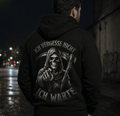 Rückansicht eines Mannes in einem schwarzen Hoodie mit Sensenmann-Motiv und Spruch Ich vergesse nicht Ich warte