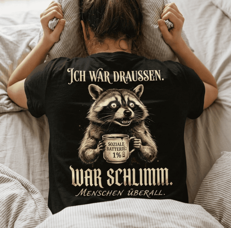 Mann trägt schwarzes T-Shirt mit humorvollem Waschbär-Motiv in Rückansicht
