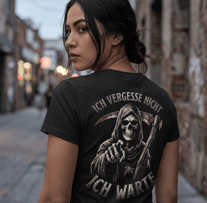 Rückansicht einer Frau in schwarzem T-Shirt mit Spruch Ich vergesse nicht Ich warte und Sensenmann-Motiv