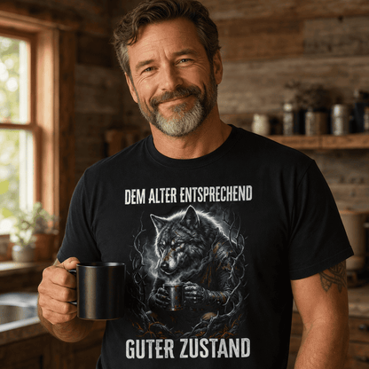 Mann trägt schwarzes T-Shirt mit Wolf und Spruch Dem Alter entsprechend guter Zustand